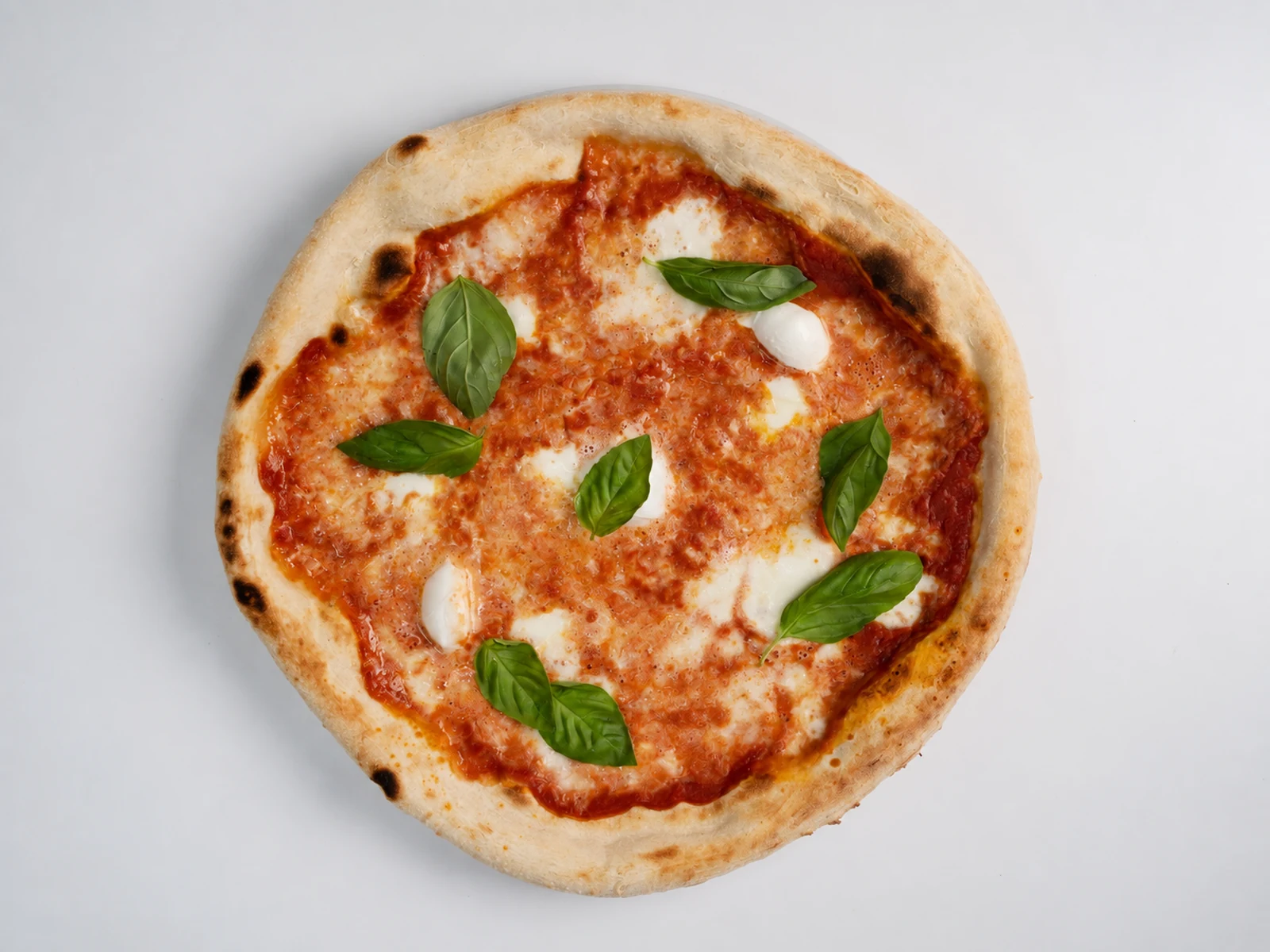 Pizza appena sfornata di Pizziamo+1 con basilico fresco
